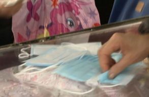 Egy n� maszkokat d�rzs�lt a t�zezrek �ltal v�gics�kolt ereklyetart�hoz a Szent Piroska zar�ndoklaton